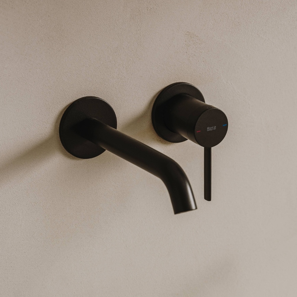 Lifestyle image of the Roca Ona Matt Black Wall Mounted Basin Mixer Tap installed on a bathroom wall